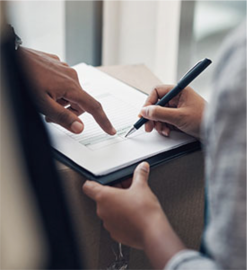 Person writing signature on a document